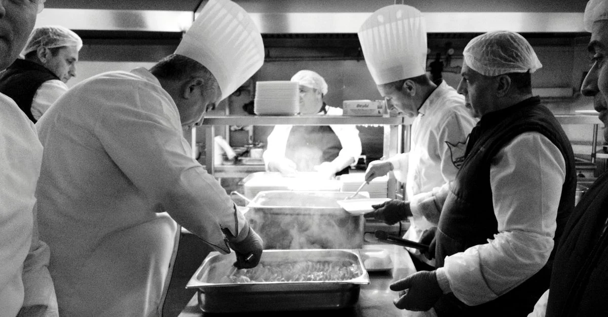 Des chefs au travail dans une cuisine animée d'Istanbul, créant une magie culinaire en noir et blanc.