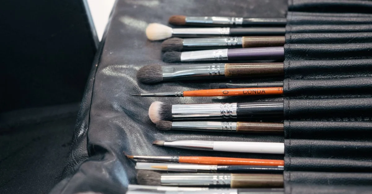 Une collection de pinceaux de maquillage professionnels soigneusement disposés dans une trousse noire, parfaits pour l'application cosmétique.